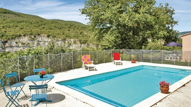 A swimming pool with a view of a green hillside, a fenced patio area with chairs and tables, and a potted plant. - 3 bedroom nice home in Saint-Thomé (Saint-Thomé)