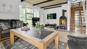 Een moderne woonkamer met een open haard, lederen meubels en een televisie.
