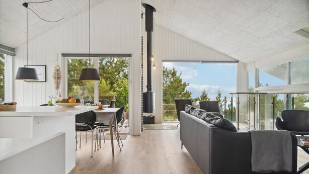 Un interior moderno con cocina, comedor y una zona de estar acogedora con vistas al exterior.