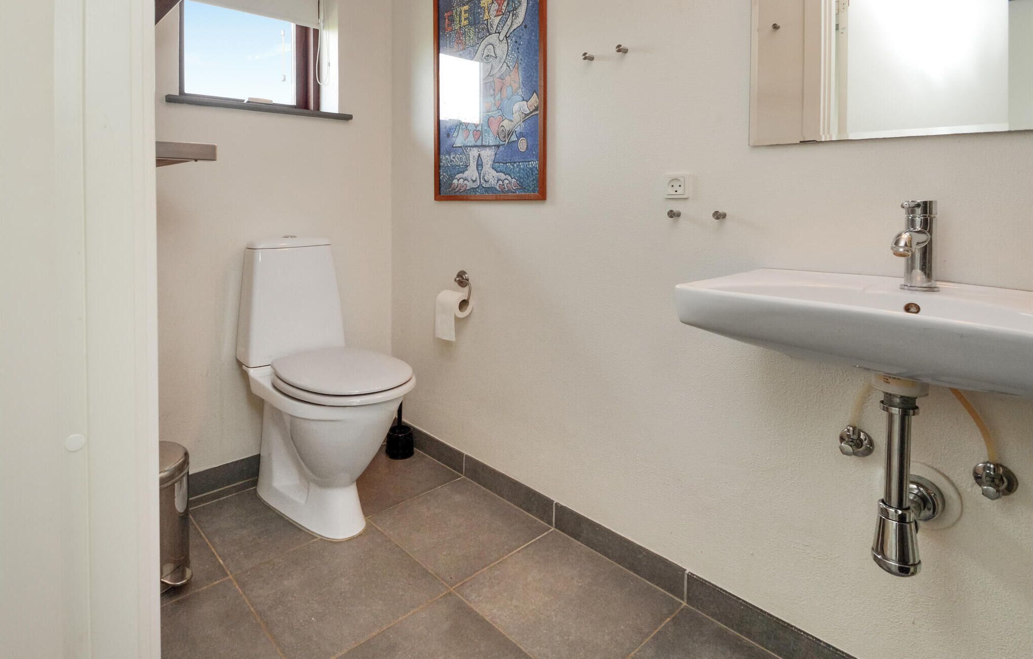 Ein Badezimmer mit Toilette, Waschbecken und Fenster.