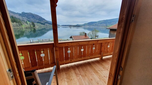 A wooden balcony with a view of a lake and hills. - Double room Primerl - Anderlbauer am See (Schliersee)