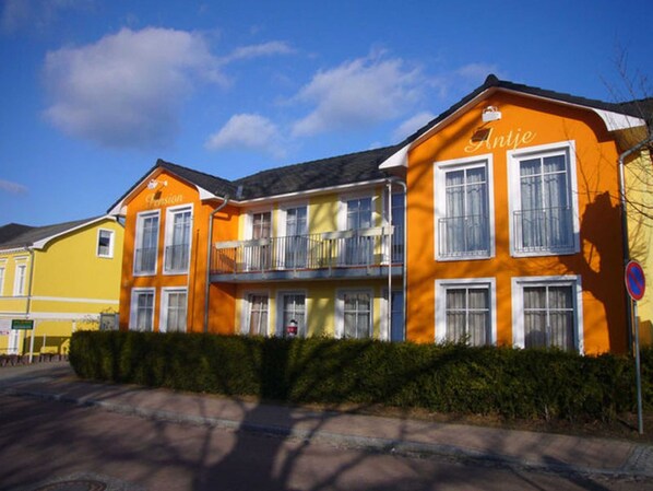 A multi-story building with balconies and a sign that reads "Antje".