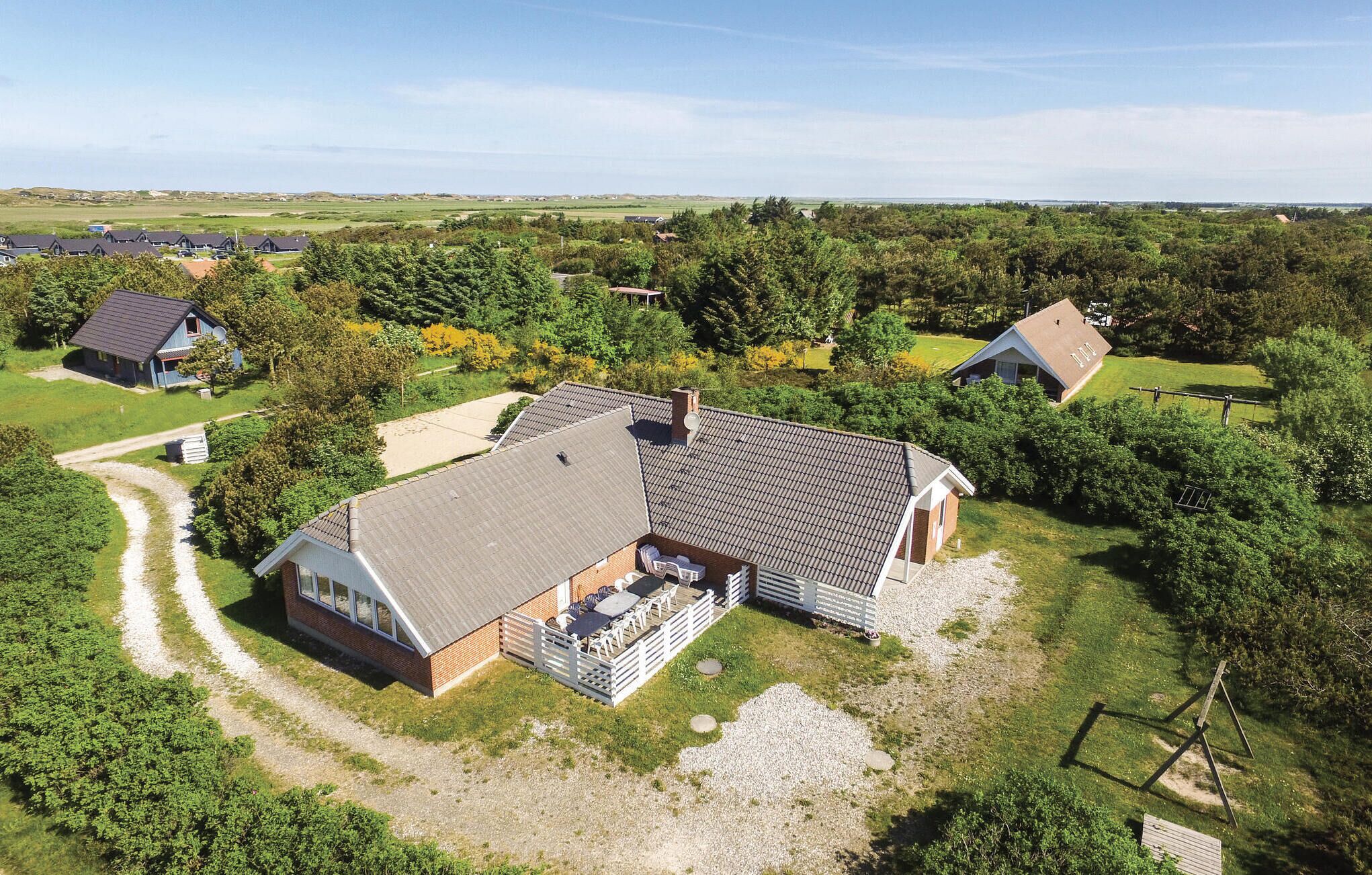 Une grande maison dotée d’un vaste patio, entourée d’un paysage rural.