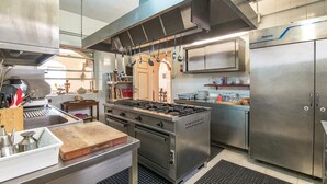 Una cocina moderna con electrodomésticos de acero inoxidable, una isla central y un colgador para ollas.