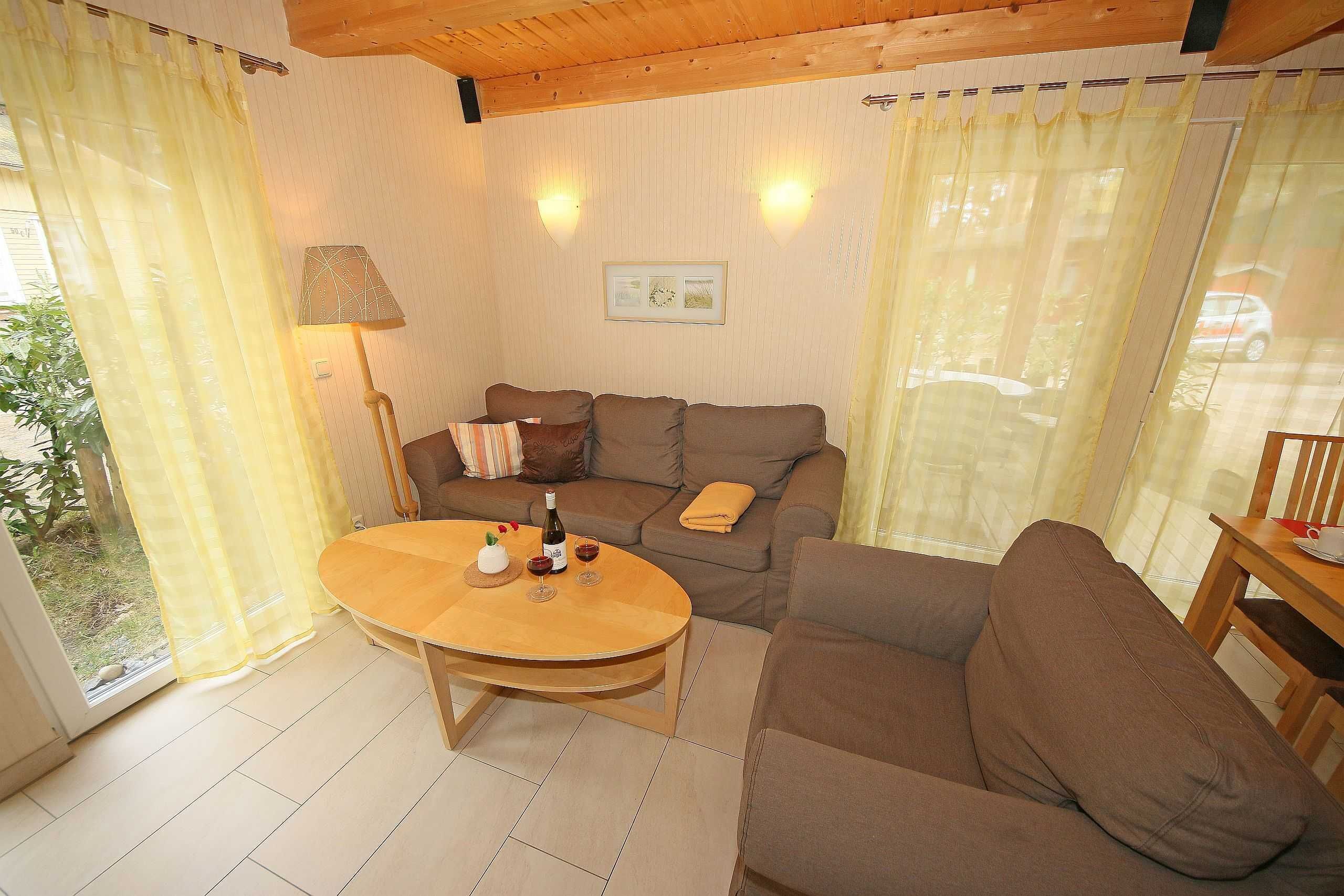 A cozy living room with a brown sofa, a wooden coffee table, and a lamp.