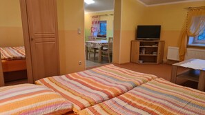 A room with a bed, a television, a bookshelf, and a window with curtains. - Apartment 2/ 2-room (45m²; 1-2 pers.) - Country vacation near Ostseebad Rerik (Biendorf)