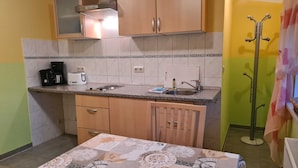 A compact kitchen with a single countertop, a sink, and wooden cabinets. - Apartment 2/ 2-room (45m²; 1-2 pers.) - Country vacation near Ostseebad Rerik (Biendorf)