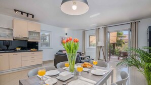 Un moderno comedor con una mesa lista para el desayuno, con zumo de naranja y pastelería.