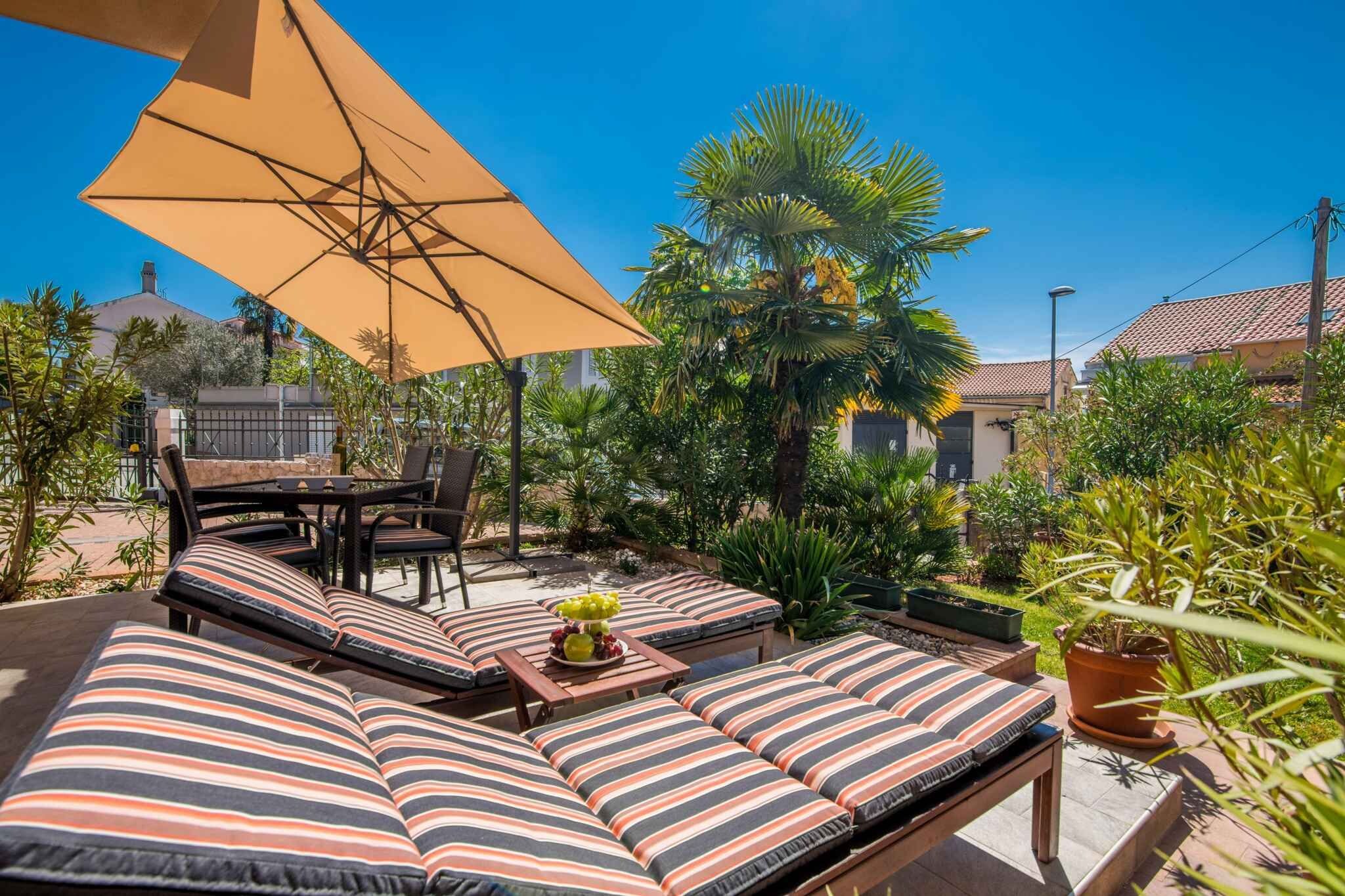 Un espace extérieur aménagé avec des coussins à rayures, une table sur laquelle est posé un panier de fruits et un grand parasol.