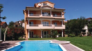 A two-story building with a swimming pool in front.