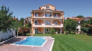A two-story building with a swimming pool in the front yard.