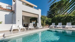 A poolside area with a clear blue pool, white lounge chairs, and a white building with a covered entrance. - Pet friendly apartment in Pula with WiFi (Pula)