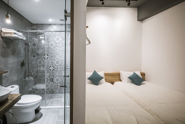 A modern bathroom with a glass shower enclosure, a toilet, and a sink.
