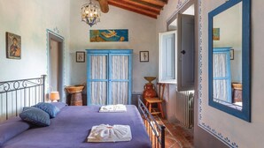 A room with a bed, a chair, a table, a radiator, and a large mirror. - Beautiful home in Reggello FI (Reggello FI)