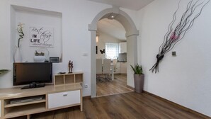 Un saló modern amb televisió, un moble de divinització de fusta i una paret amb una citació motivacional.