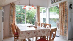 A dining area with a table covered in a patterned tablecloth, surrounded by wooden chairs. - Pet friendly home in Ansager with WiFi (Ansager)