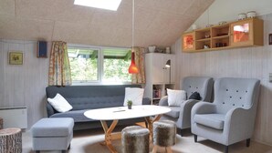 A modern living room with a grey sofa, a round coffee table, and two grey armchairs. There is a wooden cabinet above the sofa and a small round stool in front of the table. - Pet friendly home in Ansager with WiFi (Ansager)