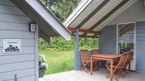 A covered porch with a wooden table and four chairs, a welcome sign, and a potted plant. - Pet friendly home in Ansager with WiFi (Ansager)
