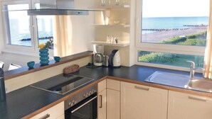 Una cucina moderna con vista sul mare, dotata di fornello, forno e macchina da caffè.