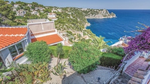 A coastal residential area with terraced houses, a clear view of the sea, and a garden with various plants. - Gorgeous apartment in Jávea with swimming pool (Jávea)