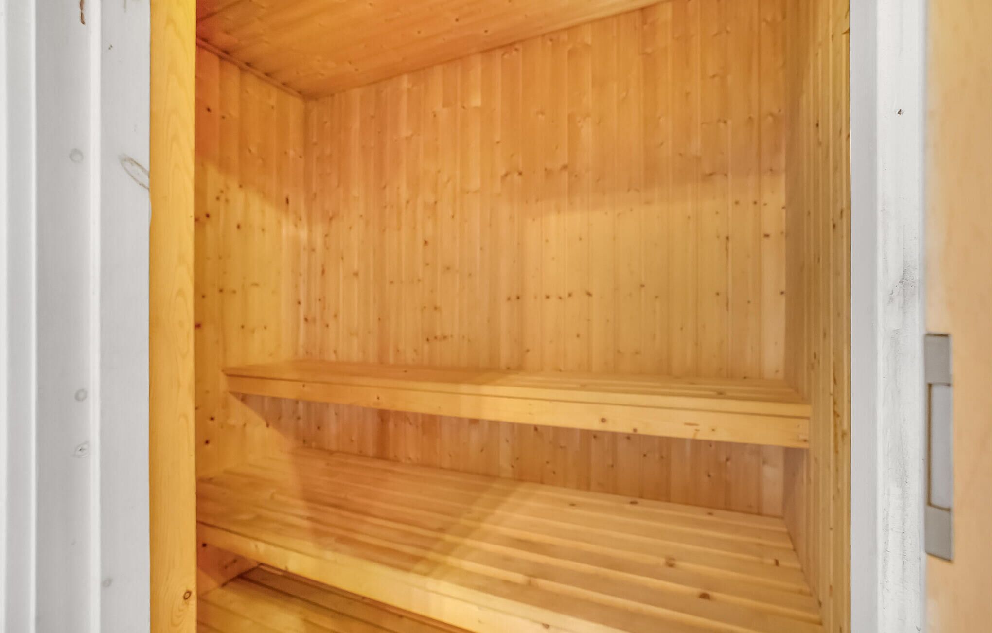 A wooden interior with two shelves and a slatted floor.