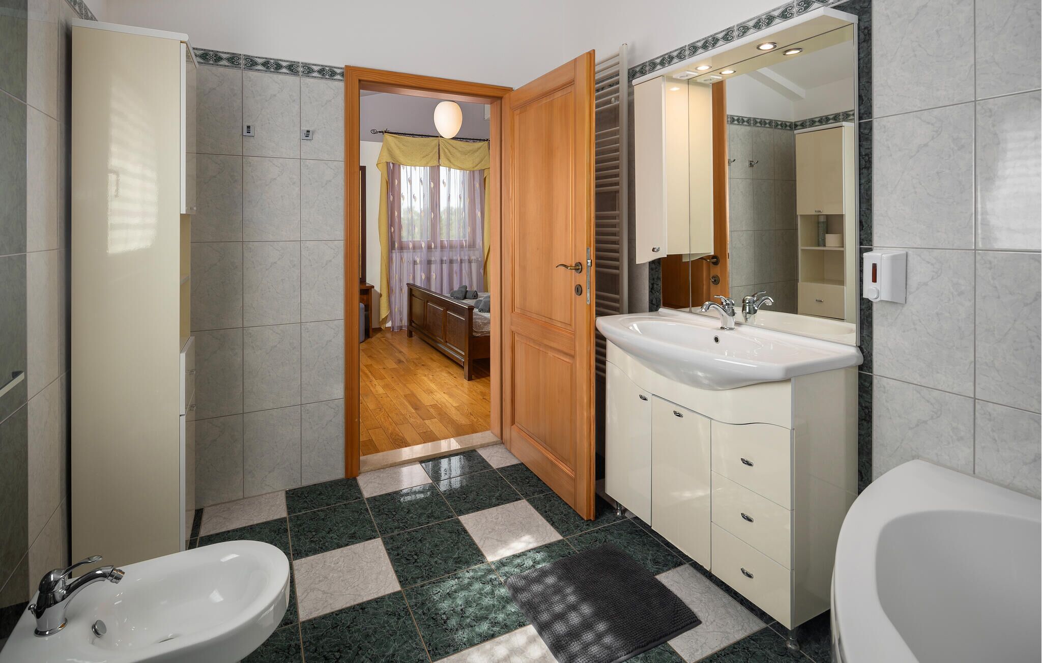 A modern bathroom with a large sink, a bathtub, and a shower area.