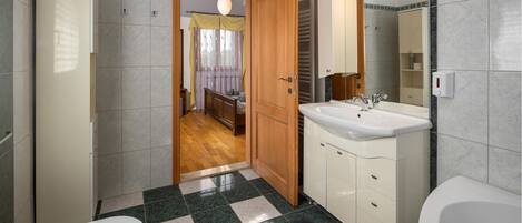A modern bathroom with a large sink, a bathtub, and a shower area.
