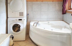 Bathroom features a front-loading washing machine and a standalone bathtub.