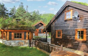 Experience the warmth of a rustic cabin-style hotel surrounded by lush greenery.