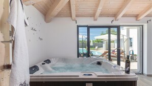 A hot tub in a room with wooden beams, a view of a pool and outdoor seating. - Gorgeous home in Barban with sauna (Barban)