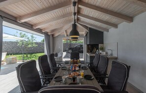 A dining area with a long table, black chairs, and a hanging light fixture. - Gorgeous home in Barban with sauna (Barban)