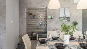 A modern dining area with a wooden wall, a framed Eiffel Tower picture, and a suitcase on a bench. - Gorgeous home in Barban with sauna (Barban)