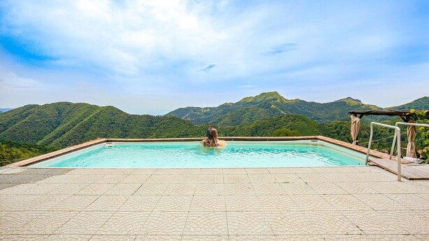 Una piscina con vista sulle montagne verdi.