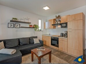 A modern kitchen with wooden cabinets, a built-in oven, and a microwave.
