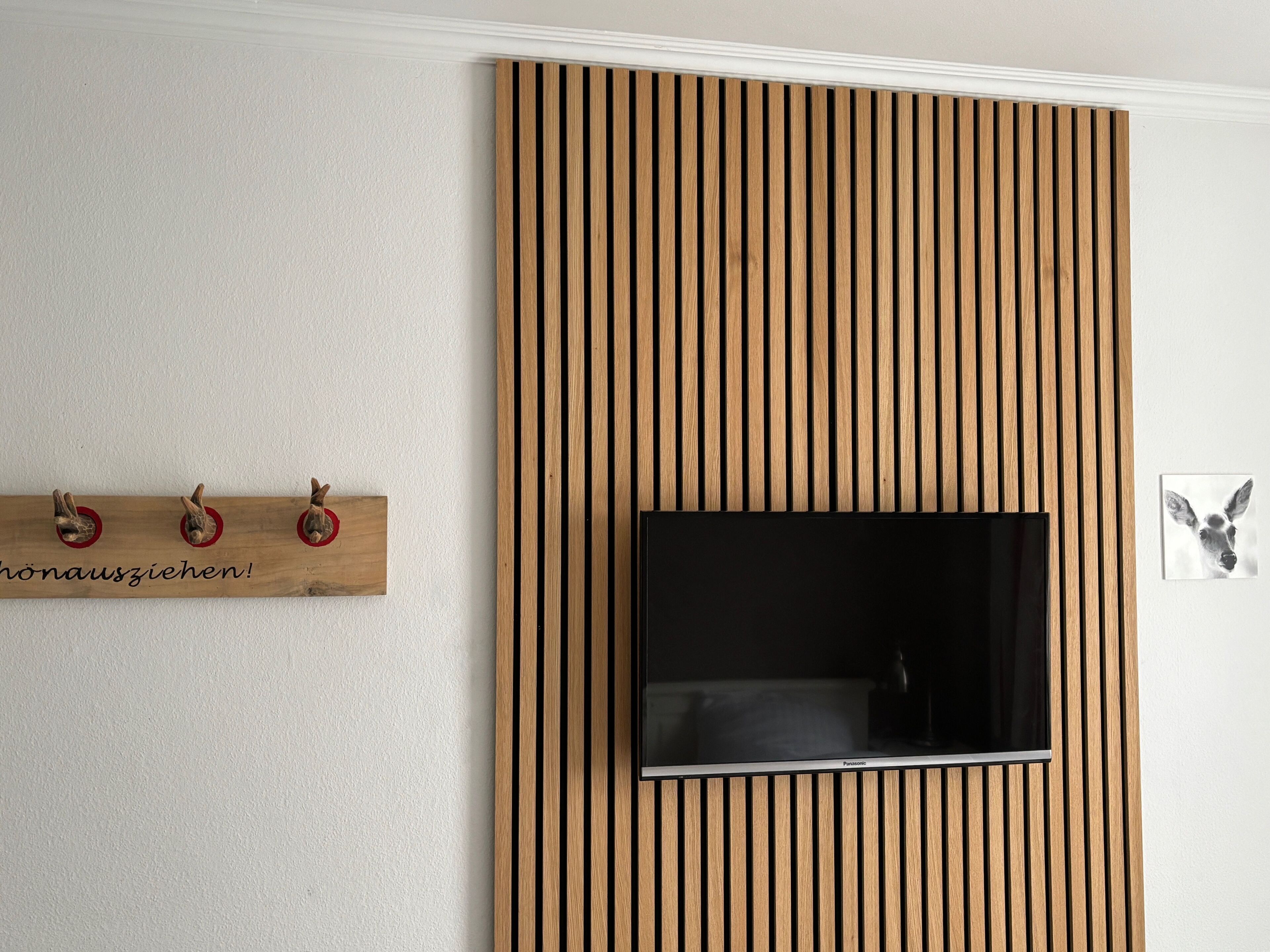 Televisor de pared con diseño de panel de madera.