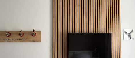 A wall-mounted television with a wooden panel design.