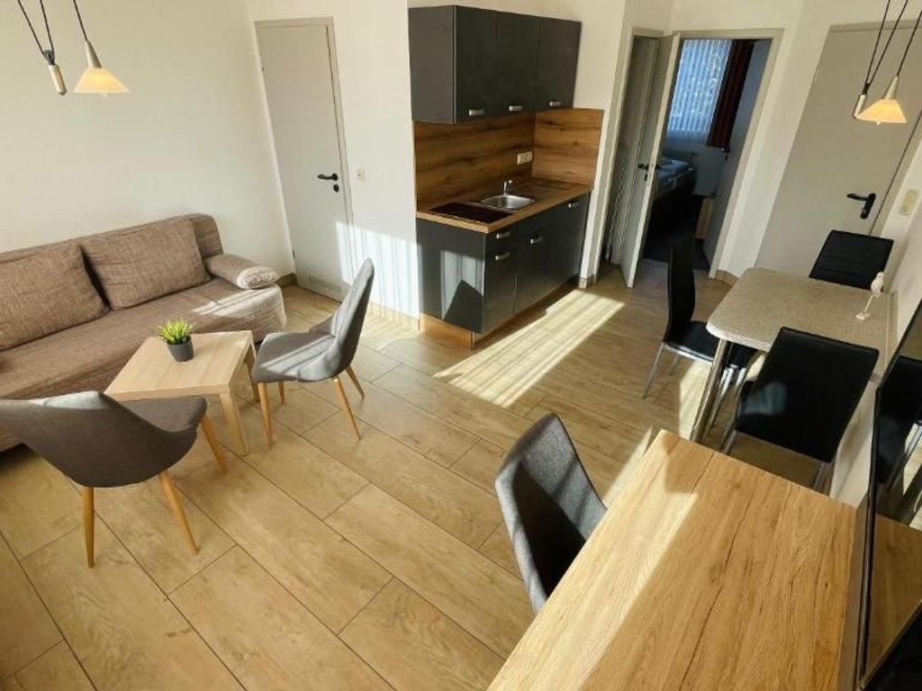 A compact living space with a kitchenette, a dining area, and a seating area.