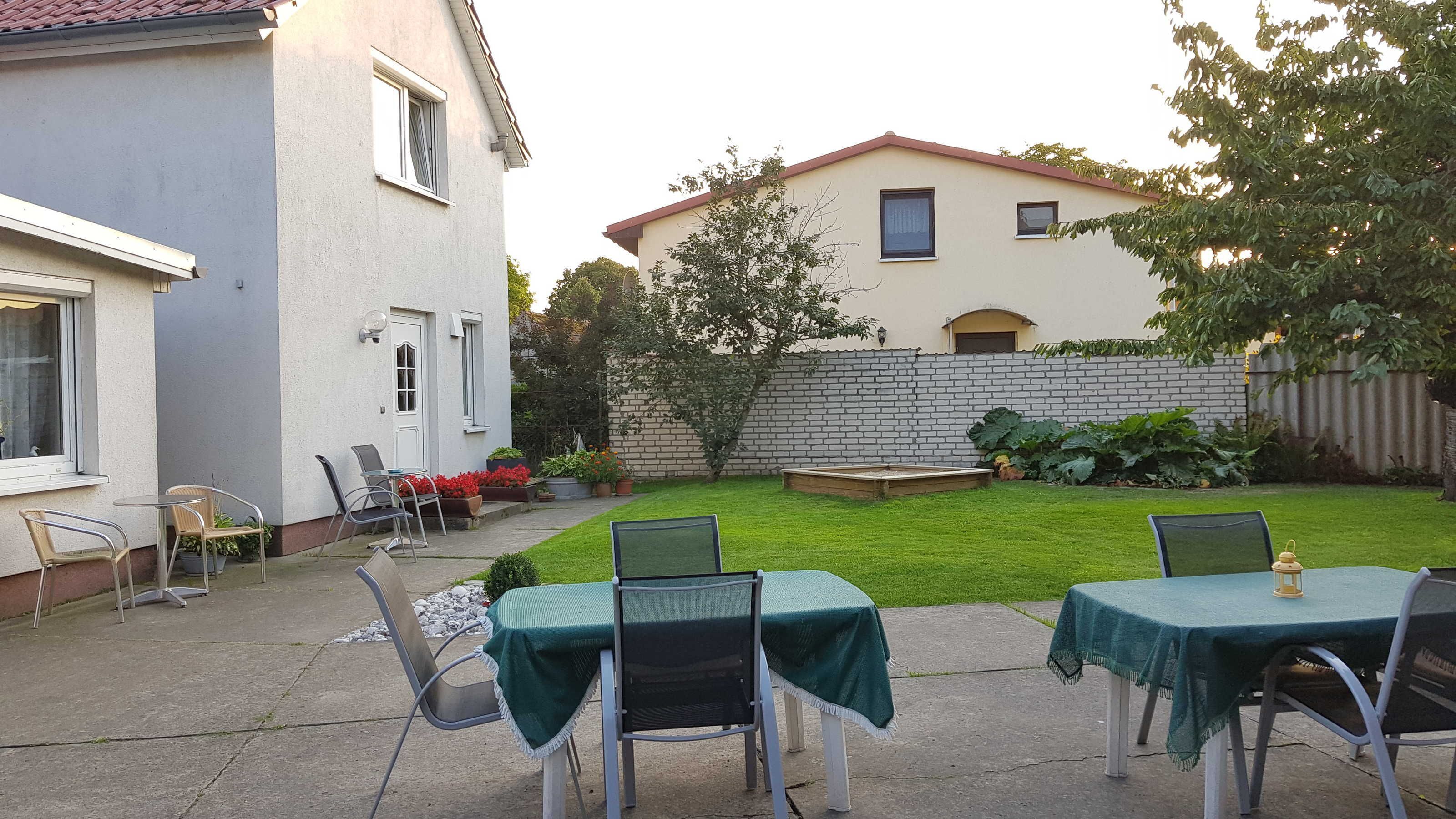 A patio with outdoor seating and a small garden area.
