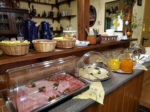 A buffet setup with various food items, baskets, and a coffee station.