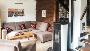 Een gezellige woonkamer met een bank, salontafel en open haard.