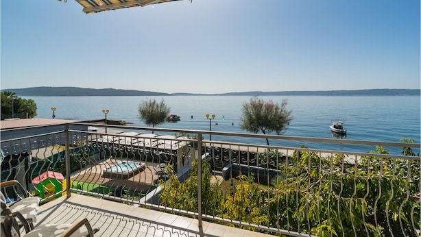 A terrace with a view of a lake, a boat, and a distant shoreline.