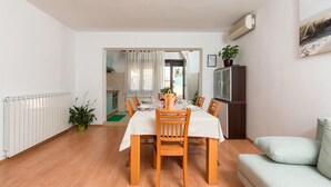 A compact living space with a dining area, kitchenette, and a sofa. - Amazing apartment in Pula (Pula)