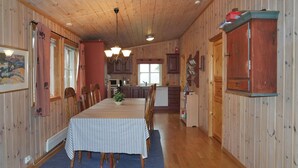 A cozy cabin interior with a dining area, wooden walls, and a kitchen. - Amazing home in Sjusjøen with sauna (Sjusjøen)