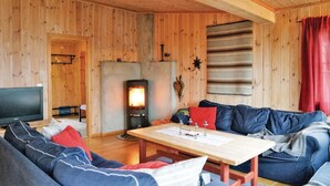 A cozy cabin interior with a wooden interior, a fireplace, a television, and a sofa. - Amazing home in Sjusjøen with sauna (Sjusjøen)