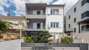 A modern two-story building with balconies, large windows, and a gated entrance. - Beach front apartment in Crikvenica (Crikvenica)