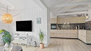 Eine moderne Küche mit Holzschränken, einem schwarzen Backofen und einer gefliesten Spritzschutzwand.