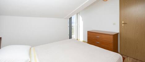 Ein Schlafzimmer mit einem Bett, einem Holzschrank und einer Tür.