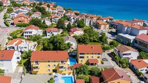 Un quartier résidentiel avec des maisons, une piscine et une vue sur la mer.