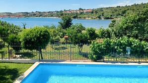 A swimming pool with a view of a lake and distant buildings. - Stunning home in Pula (Pula)