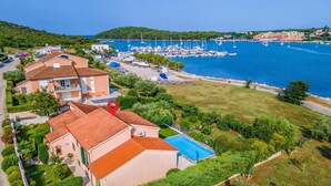 A coastal hotel with a swimming pool, marina, and lush greenery. - Stunning home in Pula (Pula)